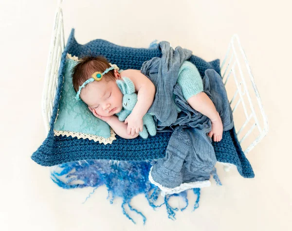 Noworodek dziewczynka śpi w małym łóżku — Zdjęcie stockowe
