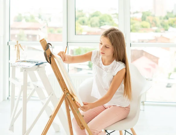 Teenager girl makes pencil sketch on canvas — Stock Photo, Image