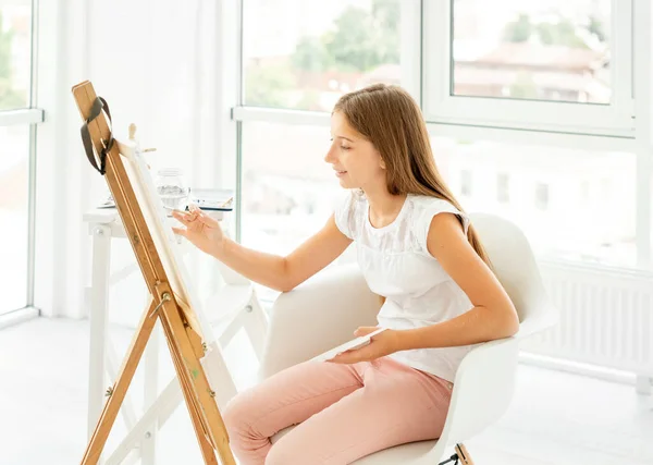 Teenager girl makes pencil sketch on canvas — Stock Photo, Image