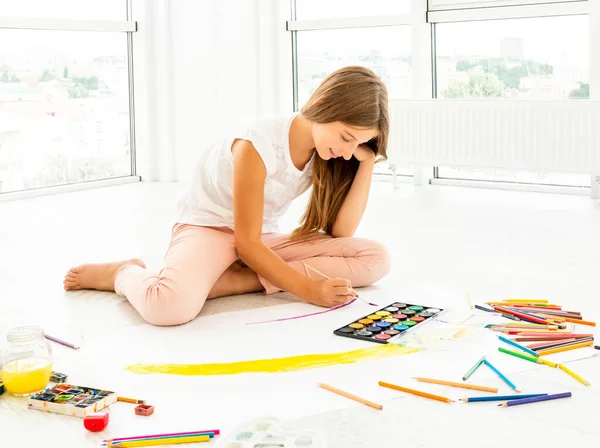 Jovem adolescente sentada, pintura em papel — Fotografia de Stock