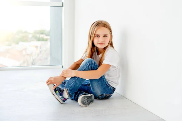 Aranyos gyerek lány alkalmi ruhák ül a szobában — Stock Fotó