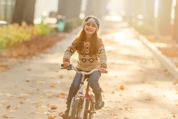 Happy girl riding bike in park — Stock Photo, Image