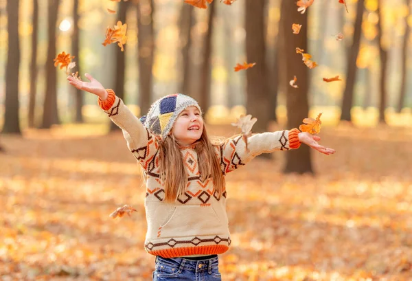 Klein meisje dat bladeren overgeeft — Stockfoto