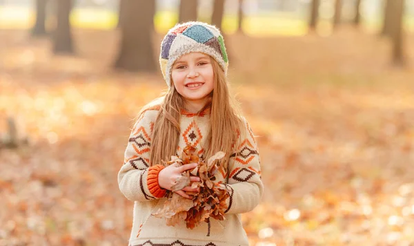 Kleines Mädchen wirft Blätter weg — Stockfoto