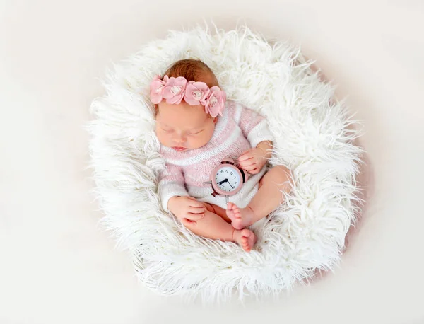 Newborn baby holding clock — ストック写真