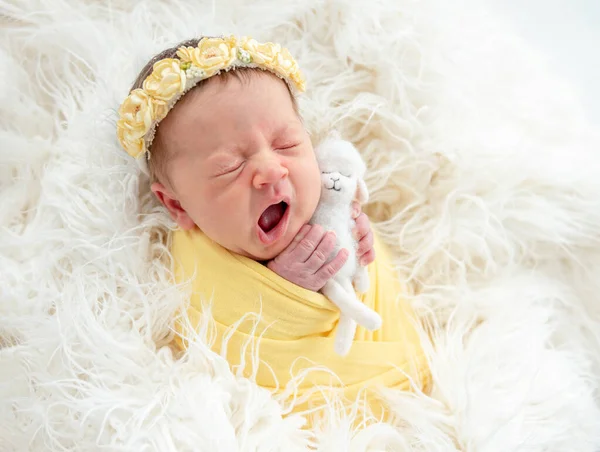 Bostezo recién nacido sosteniendo juguete —  Fotos de Stock