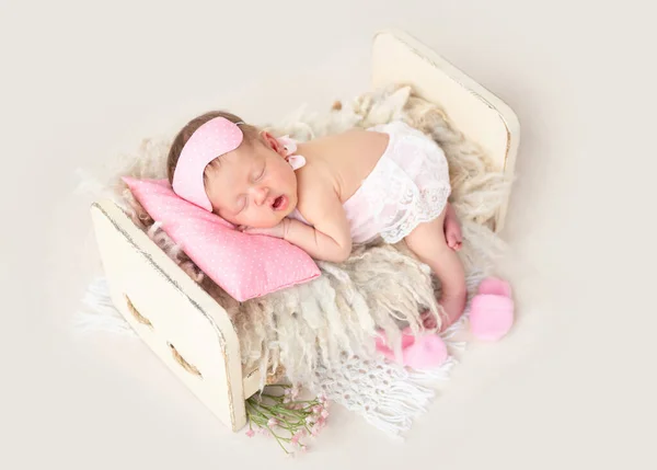 Новорожденный спит в крошечной кровати — стоковое фото