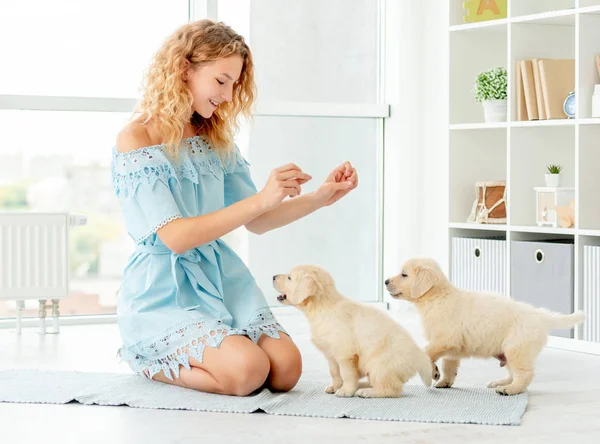 Gelukkig meisje onderwijs puppies — Stockfoto