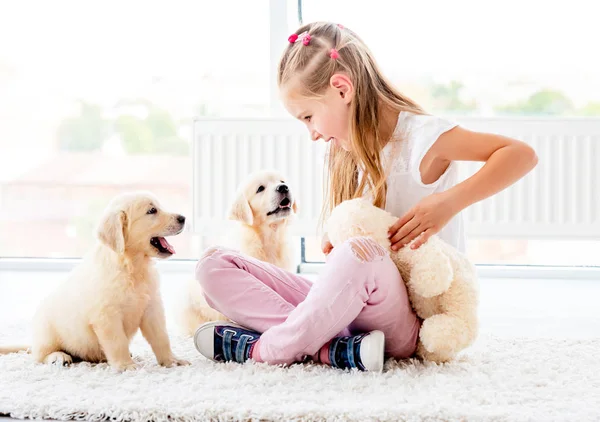 Puppies spelen met vrolijk meisje — Stockfoto