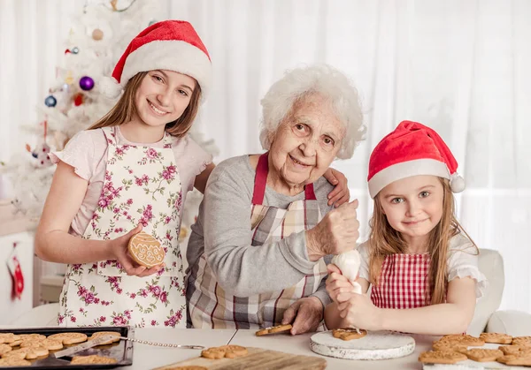 Avó com netas embeber creme de decoração biscoitos com creme — Fotografia de Stock