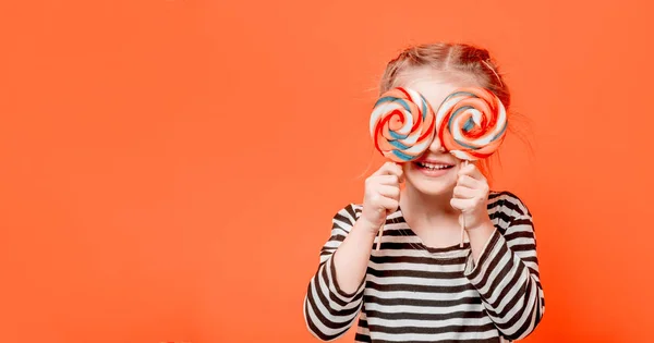 Kid flicka med lollypops framför hennes ögon — Stockfoto