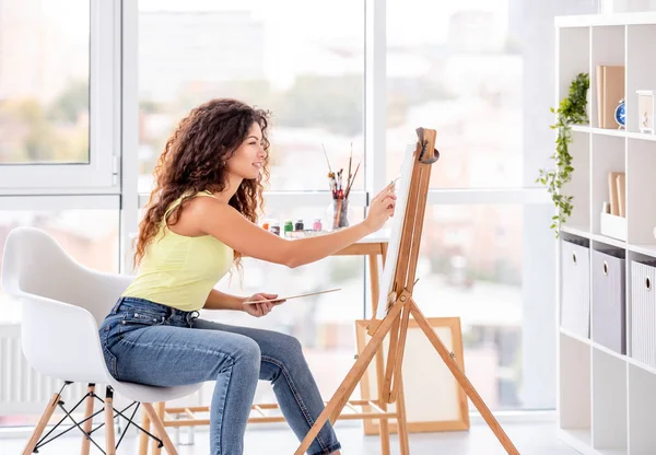 Artista sorrindo pintura no cavalete — Fotografia de Stock