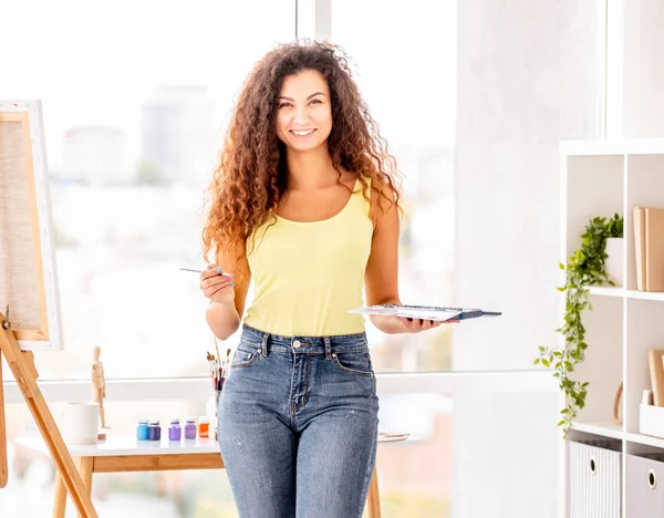 Artist holding paints and tassel — Stock Photo, Image