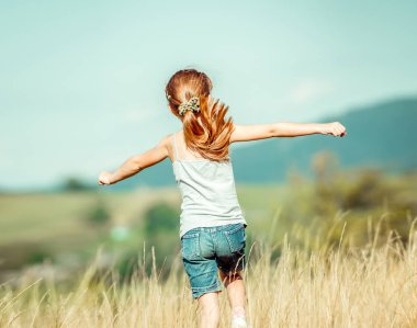 küçük kız bir çayır ile çalışır