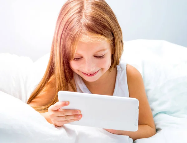 Écolière avec tablette au lit à — Photo