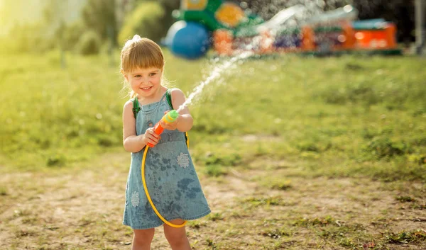 Linda niña jugando pistola de agua — Foto de Stock