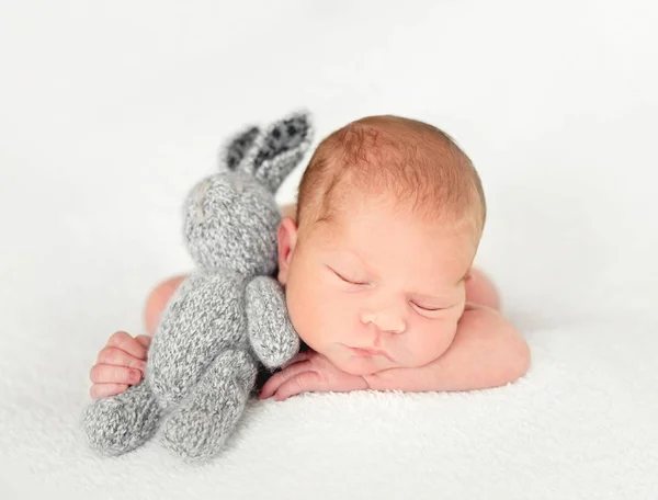 Pequeño bebé acostado con juguete para liebre — Foto de Stock