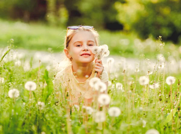 Niña afuera en el campo de diente de león —  Fotos de Stock