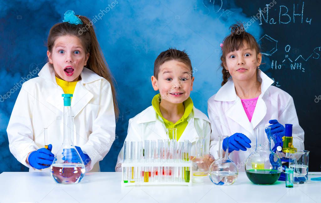three excited children after chemical experiment