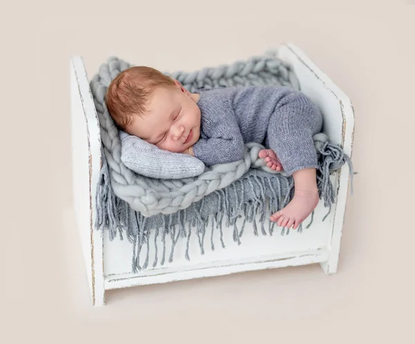 Cute newborn on tiny bed — Stock Photo, Image