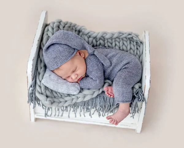 Niedliches Neugeborenes auf winzigem Bett — Stockfoto