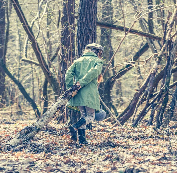 ittle cute girl builds a hut in the woods