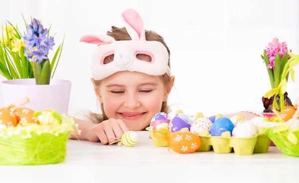 The child peals from behind the Easter decorations — Stock Photo, Image