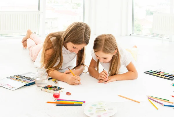 Twee kleine zusters trekt op de vloer — Stockfoto