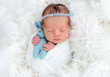 Cute newborn holding toy