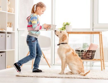 Köpeğe yemek veren kız.