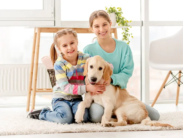 Happy sisters hugging dog — ストック写真