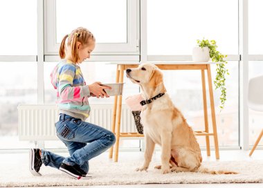 Güzel kız tatlı köpeği besliyor.