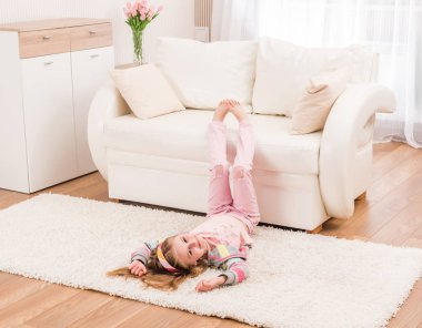 Gülümseyen kız oturma odasında germe