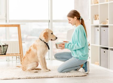 Cheerful owner feeding cute dog