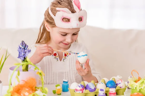 Menina colorir ovos em máscara — Fotografia de Stock