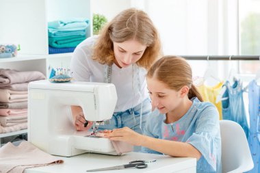 Terzi öğrenciye ders veriyor.