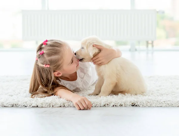 Щенок целует маленькую девочку — стоковое фото