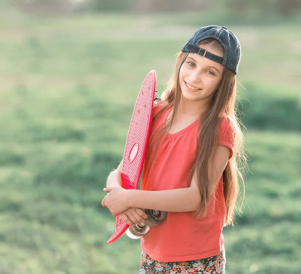 Девочка-подросток, держащая свою розовую доску — стоковое фото
