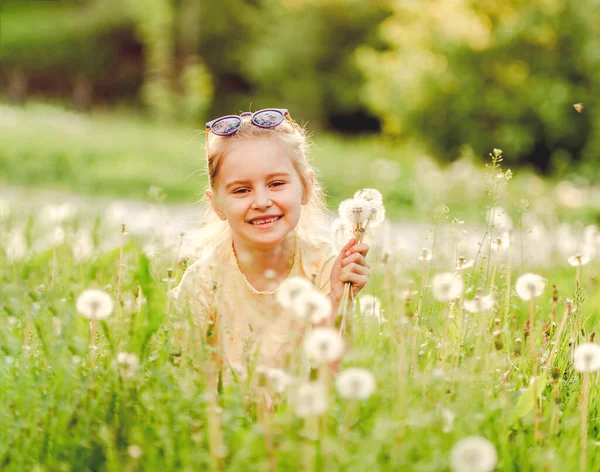 Little girl outside on dandelion field — Stock Photo, Image