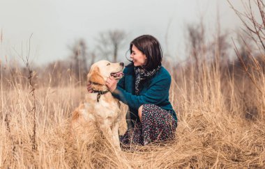 Sevimli köpeğe sarılan bir kadın