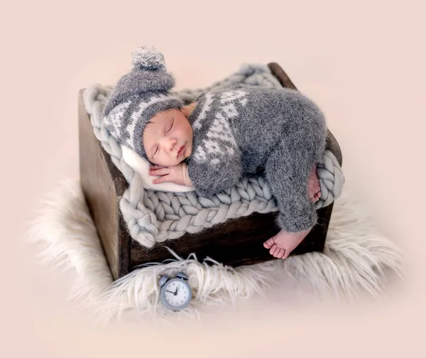 Funny newborn on tiny bed — Stock Photo, Image