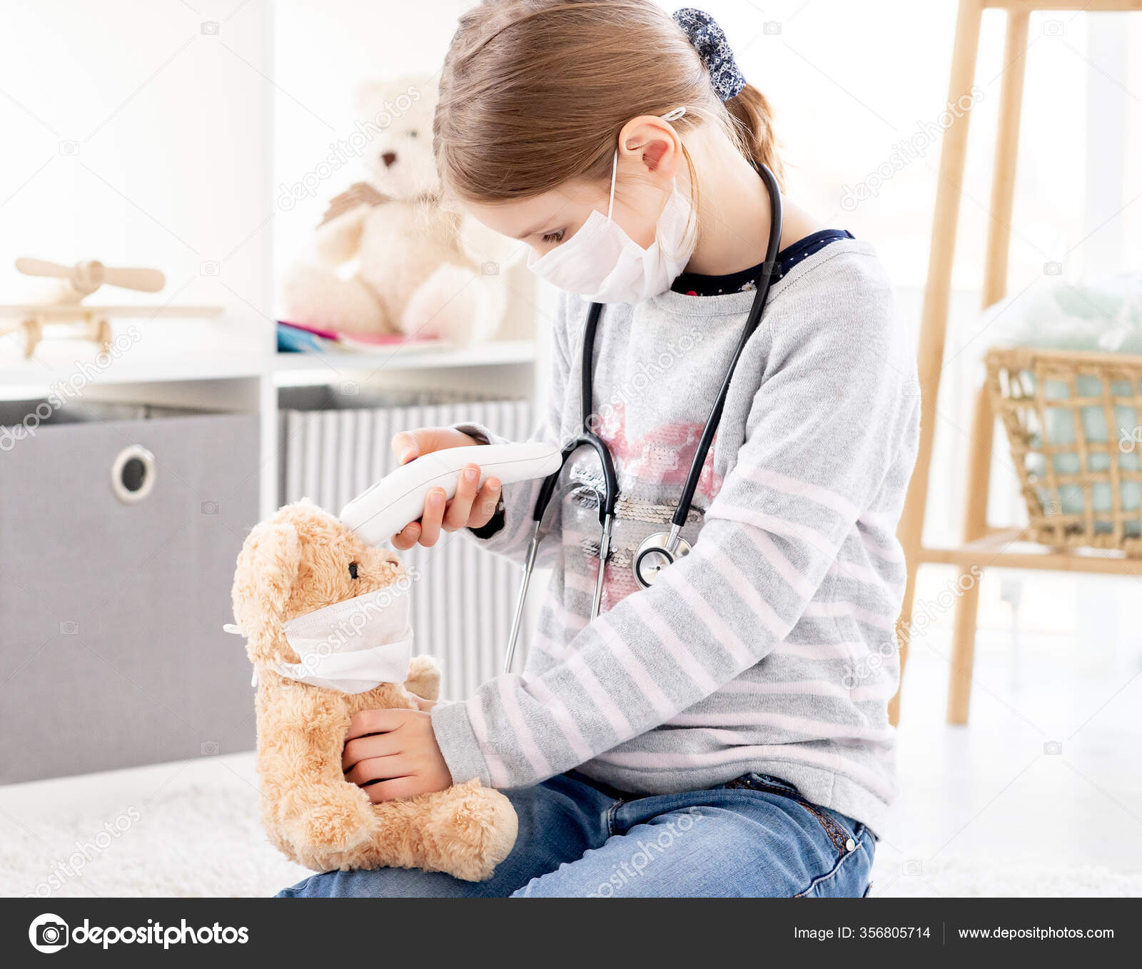 Girl measuring teddy bear temperature Stock Photo by ©tan4ikk 356805714