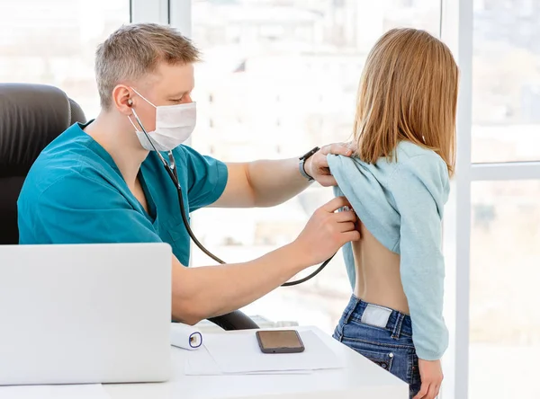 Arzt hört kleinem Mädchen zu — Stockfoto