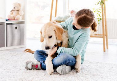 Güzel küçük kız kucağında sevimli bir köpek