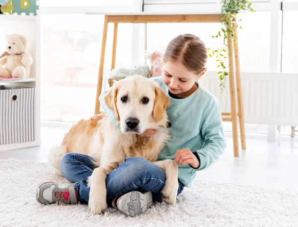 Menina segurando adorável golden retriever — Fotografia de Stock