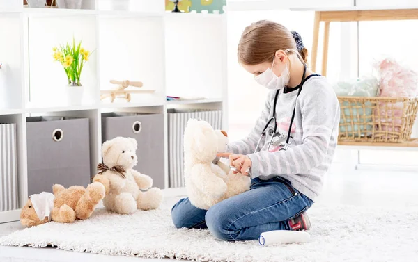 Menina bonita usando desinfetante no urso — Fotografia de Stock