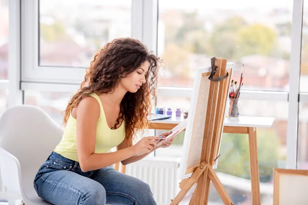 Artista sorrindo pintura no cavalete — Fotografia de Stock