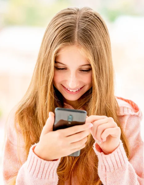 Tini lány gépelés a mobiltelefon — Stock Fotó