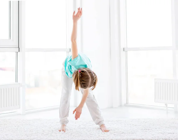 Menina desportiva fazendo exercício de moinho de vento — Fotografia de Stock