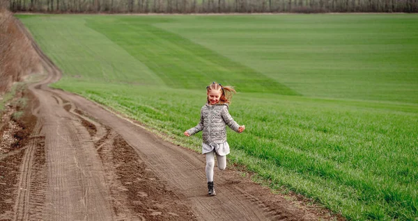 Kislány fut a tavaszi pályán — Stock Fotó